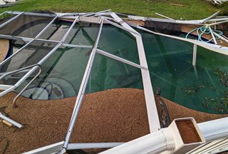 Screened pool with torn or missing screen panels letting outside debris in
