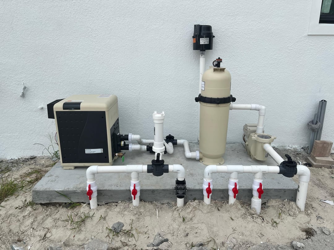 Real Sundays Pools equipment pad in Sarasota with a gas heater, cartridge filter, variable-speed pump, and a labeled Schedule 40 PVC manifold with red-handled isolation valves